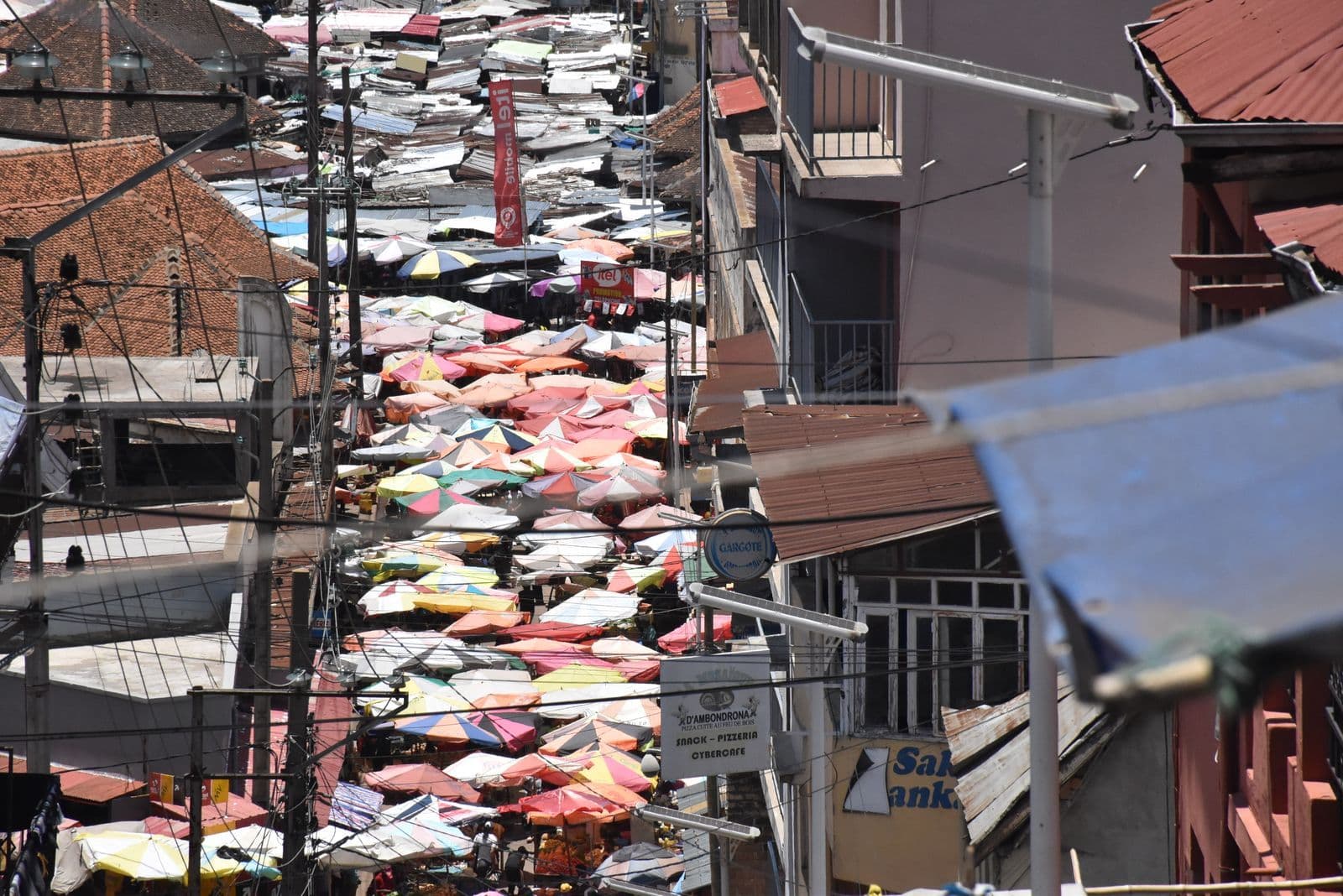 Rue commerçante du quartier d'Ambondrona, à Antananarivo, couverte de parasols de marché